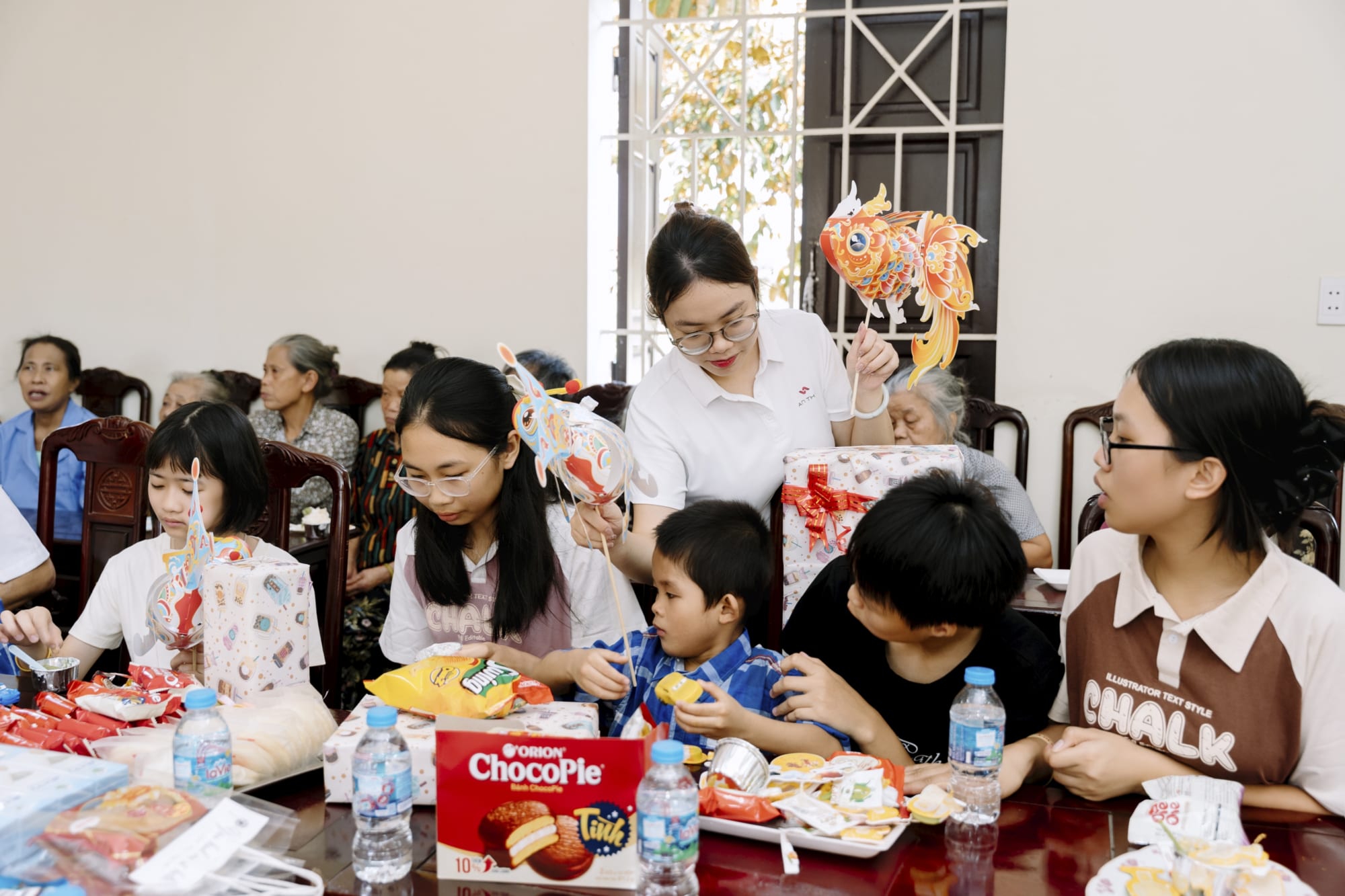 Các em nhỏ quây quần bên nhau, cùng nhận quà và tận hưởng những khoảnh khắc vui vẻ trong không khí Trung thu ấm áp tại Trung tâm
